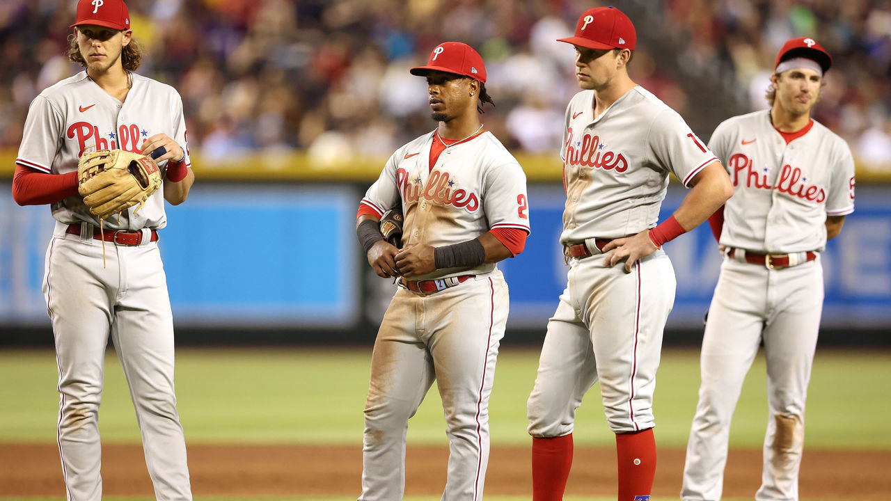PHOENIX, ARIZONA - AUGUST 29: Infielders (L-R) Alec Bohm #28, Jean Segura #2, Rhys Hoskins #17 and Bryson Stott #5 of the Philadelphia Phillies react during a break from the fifth inning of the MLB game against the Arizona Diamondbacks at Chase Field on August 29, 2022 in Phoenix, Arizona.