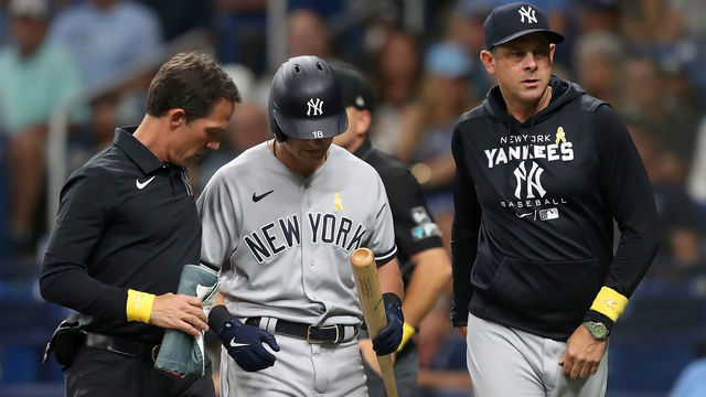 ST. PETERSBURG, FL - SEP 02: New York Yankees outfielder Andrew Benintendi (18) leaves the game with the help of the Yankees trainer and Yankees Manager Aaron Boone (17) during the MLB regular season game between the New York Yankees and the Tampa Bay Rays on September 02, 2022, at Tropicana Field in St. Petersburg, FL.