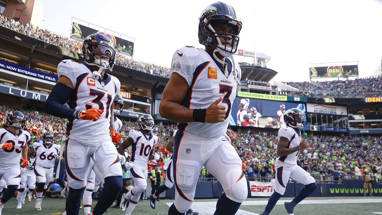SEATTLE, WASHINGTON - SEPTEMBER 12: Justin Simmons #31 (L) and Russell Wilson #3 of the Denver Broncos (C) enter the field before playing against the Seattle Seahawks at Lumen Field on September 12, 2022 in Seattle, Washington.