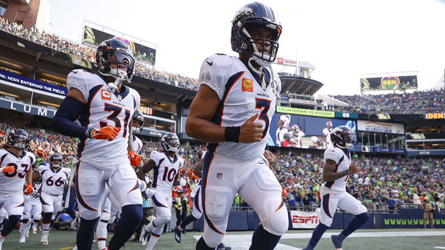 SEATTLE, WASHINGTON - SEPTEMBER 12: Justin Simmons #31 (L) and Russell Wilson #3 of the Denver Broncos (C) enter the field before playing against the Seattle Seahawks at Lumen Field on September 12, 2022 in Seattle, Washington.