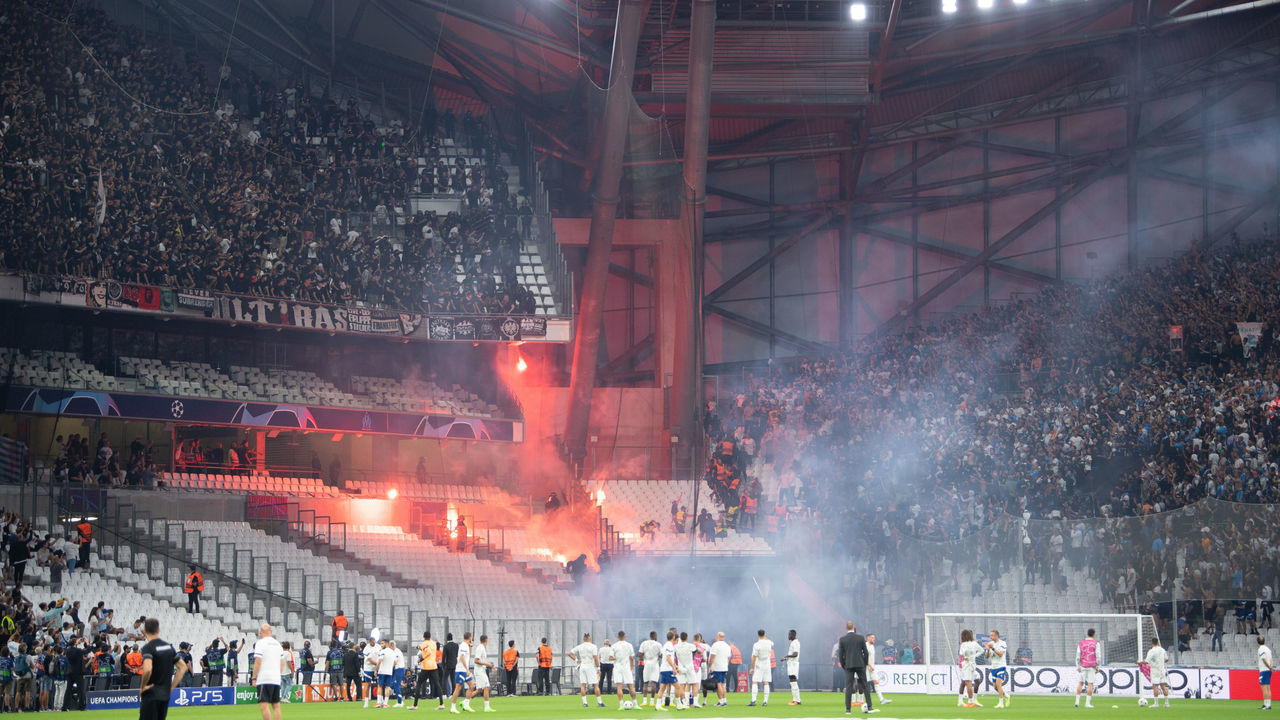 13 September 2022, France, Marseille: Soccer: Champions League, Olympique Marseille - Eintracht Frankfurt, Group stage, Group D, Matchday 2, Orange Vélodrome. The blocks of Eintracht (l) and Marseille Ultras shoot fireworks at each other. Photo: Sebastian Gollnow/dpa