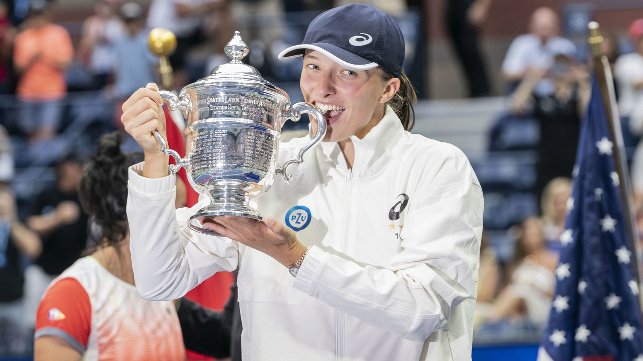 NEW YORK, USA - SEPTEMBER 10: Iga Swiatek of Poland bites the trophy after victory in final of US Open Championships against Ons Jabeur of Tunisia at USTA Billie Jean King National Tennis Center in New York on September 10, 2022. Swiatek won in straight sets. It was her second Grand Slam victory in this year and first ever for Polish woman.