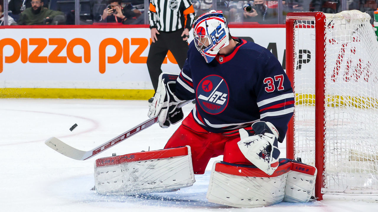 WINNIPEG, MB - APRIL 06: Goaltender Connor Hellebuyck #37 of the Winnipeg Jets makes a save during first period action against the Detroit Red Wings at Canada Life Centre on April 06, 2022 in Winnipeg, Manitoba, Canada.