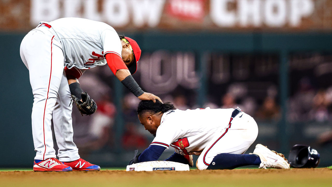 ATLANTA, GA - SEPTEMBER 17: Jean Segura #2 of the Philadelphia Phillies checks on an apparently injured Ozzie Albies #1 of the Atlanta Braves after Albies slid into second base in the bottom of the fourth inning of a game at Truist Park on September 17, 2022 in Atlanta, Georgia.
