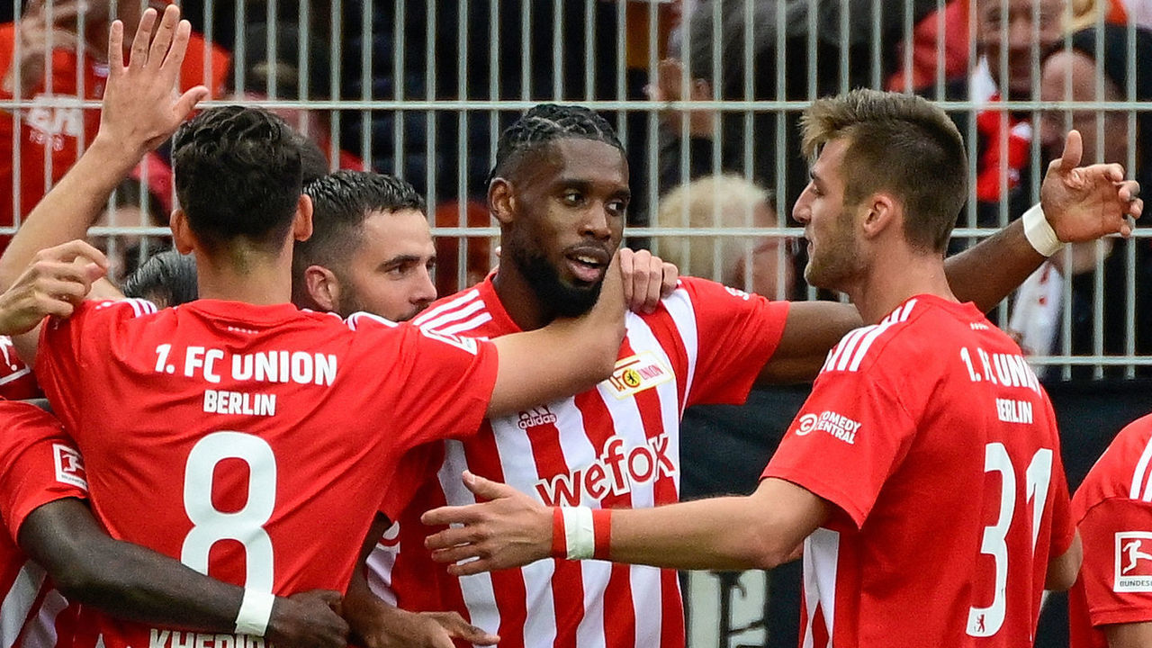 Union Berlin's French forward Jordan Siebatcheu (C) celebrates scoring the opening goal with his teammates during the German first division Bundesliga football match betwen 1 FC Union Berlin and VfL Wolfsburg in Berlin on September 18, 2022. - - DFL REGULATIONS PROHIBIT ANY USE OF PHOTOGRAPHS AS IMAGE SEQUENCES AND/OR QUASI-VIDEO ALTERNATIVE CROP