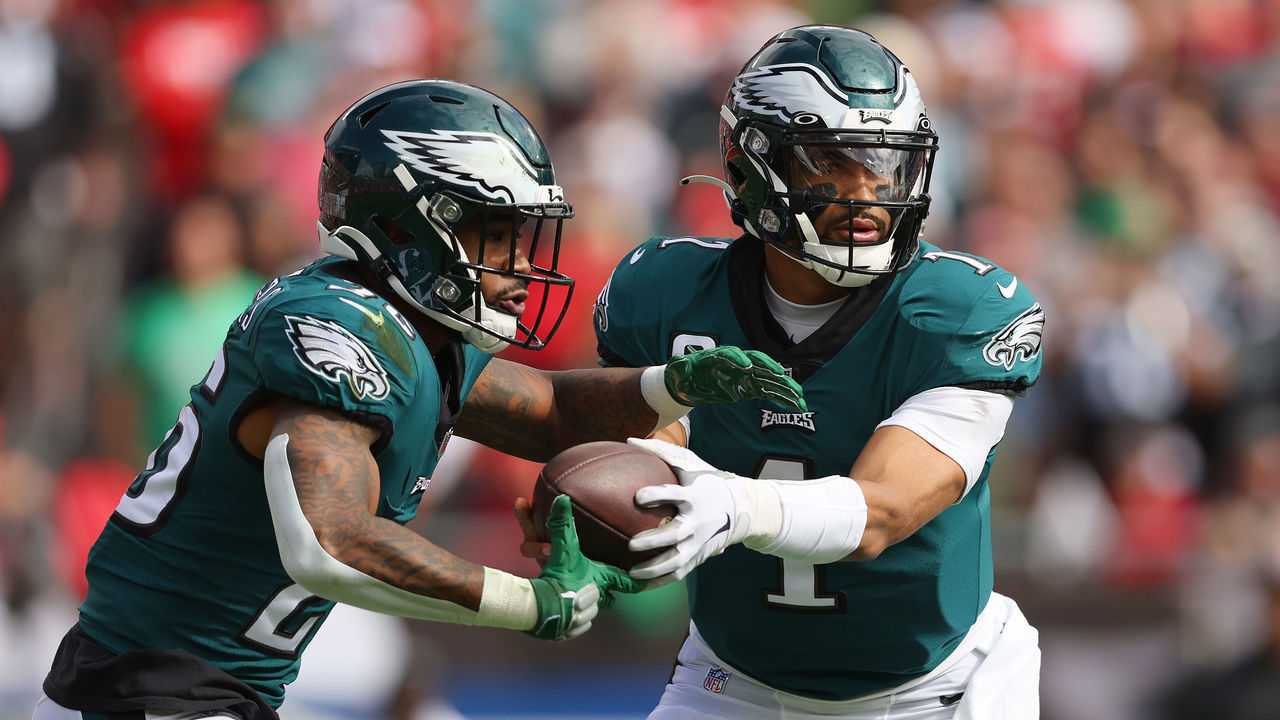 TAMPA, FLORIDA - JANUARY 16: Jalen Hurts #1 of the Philadelphia Eagles hands the ball off to Miles Sanders #26 against the Tampa Bay Buccaneers in the first half of the NFC Wild Card Playoff game at Raymond James Stadium on January 16, 2022 in Tampa, Florida.