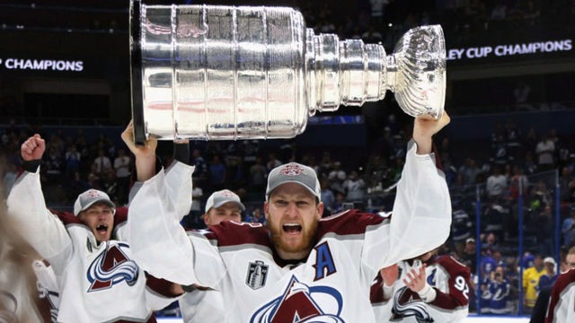 TAMPA, FLORIDA - JUNE 26: Nathan MacKinnon #29 of the Colorado Avalanche carries the Stanley Cup following the series winning victory over the Tampa Bay Lightning in Game Six of the 2022 NHL Stanley Cup Final at Amalie Arena on June 26, 2022 in Tampa, Florida.