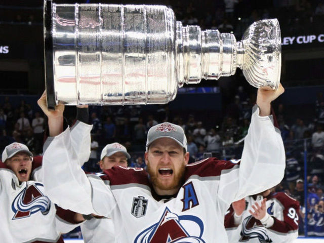 TAMPA, FLORIDA - JUNE 26: Nathan MacKinnon #29 of the Colorado Avalanche carries the Stanley Cup following the series winning victory over the Tampa Bay Lightning in Game Six of the 2022 NHL Stanley Cup Final at Amalie Arena on June 26, 2022 in Tampa, Florida.