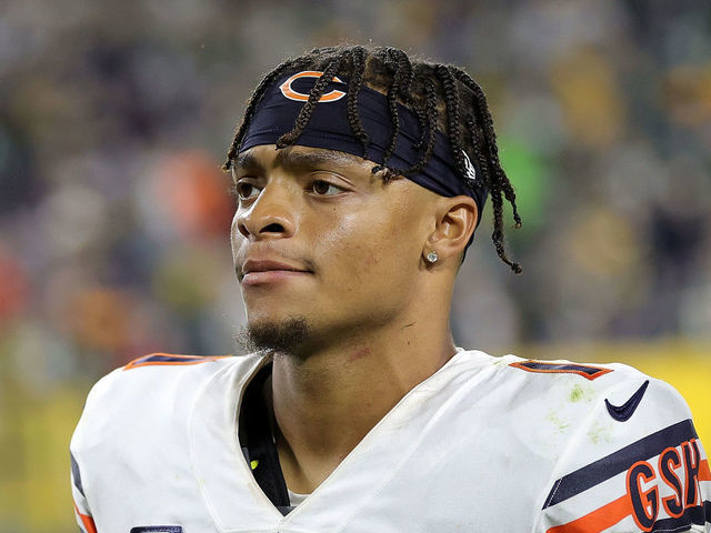 A Chicago Bears fan holds a quarterback Justin Fields jersey