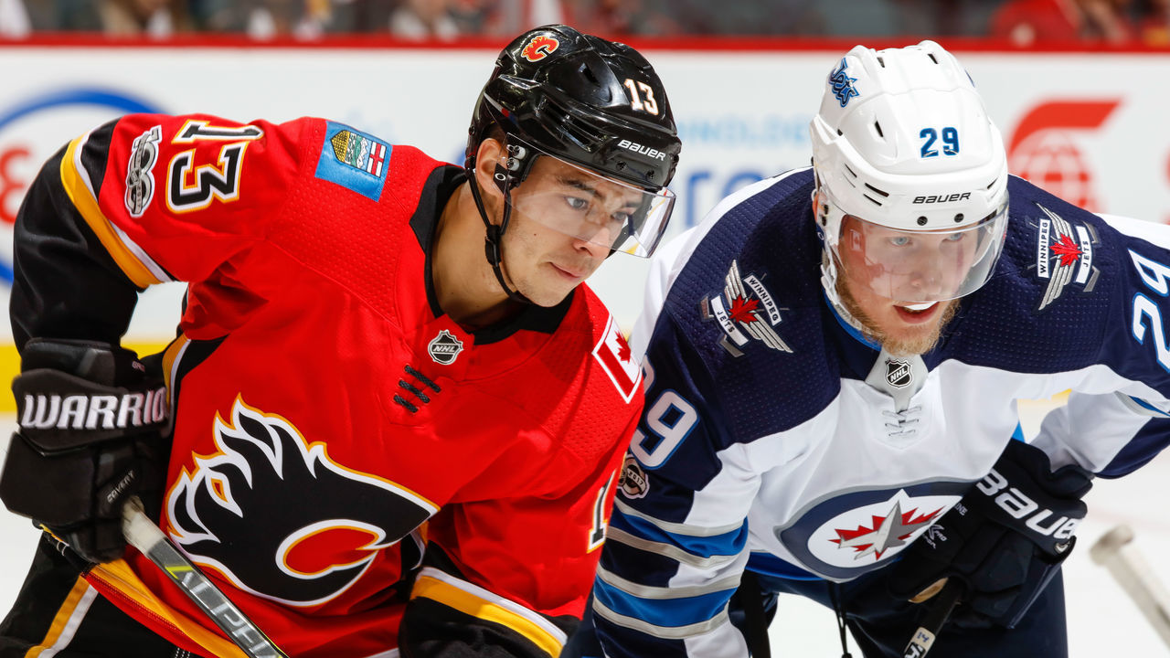 CALGARY, AB - OCTOBER 07: Johnny Gaudreau #13 of the Calgary Flames and Patrick Laine #29 of the Winnipeg Jets at face off in an NHL game against the Winnipeg Jets at the Scotiabank Saddledome on October 07, 2017 in Calgary, Alberta, Canada.