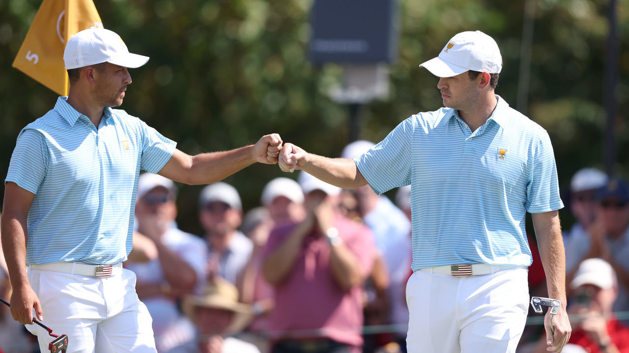 CHARLOTTE, NORTH CAROLINA - SEPTEMBER 22: (L-R) Xander Schauffele of the United States Team and Patrick Cantlay of the United States Team fist bump on the fifth green during the Thursday foursome matches on day one of the 2022 Presidents Cup at Quail Hollow Country Club on September 22, 2022 in Charlotte, North Carolina.