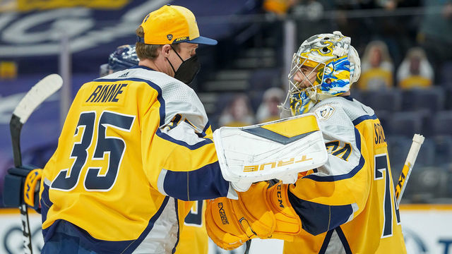 NASHVILLE, TN - MARCH 23: Pekka Rinne #35 congratulates Juuse Saros #74 of the Nashville Predators on his 2-0 shutout win against the Detroit Red Wings at Bridgestone Arena on March 23, 2021 in Nashville, Tennessee.
