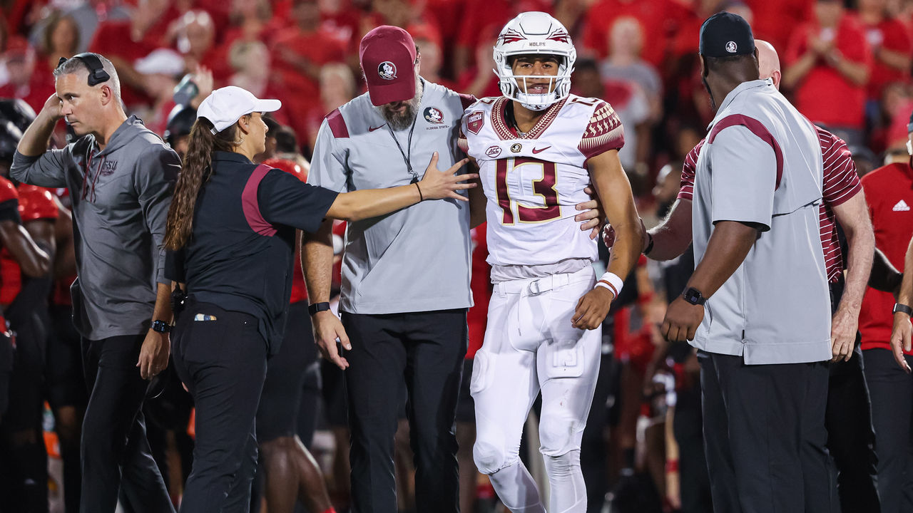 LOUISVILLE, KY - SEPTEMBER 16: Jordan Travis #13 of the Florida State Seminoles is assisted off the field after an injury during the game against the Louisville Cardinals at Cardinal Stadium on September 16, 2022 in Louisville, Kentucky.
