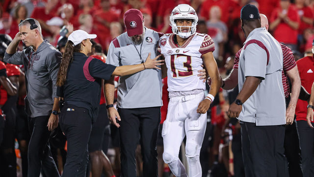 LOUISVILLE, KY - SEPTEMBER 16: Jordan Travis #13 of the Florida State Seminoles is assisted off the field after an injury during the game against the Louisville Cardinals at Cardinal Stadium on September 16, 2022 in Louisville, Kentucky.