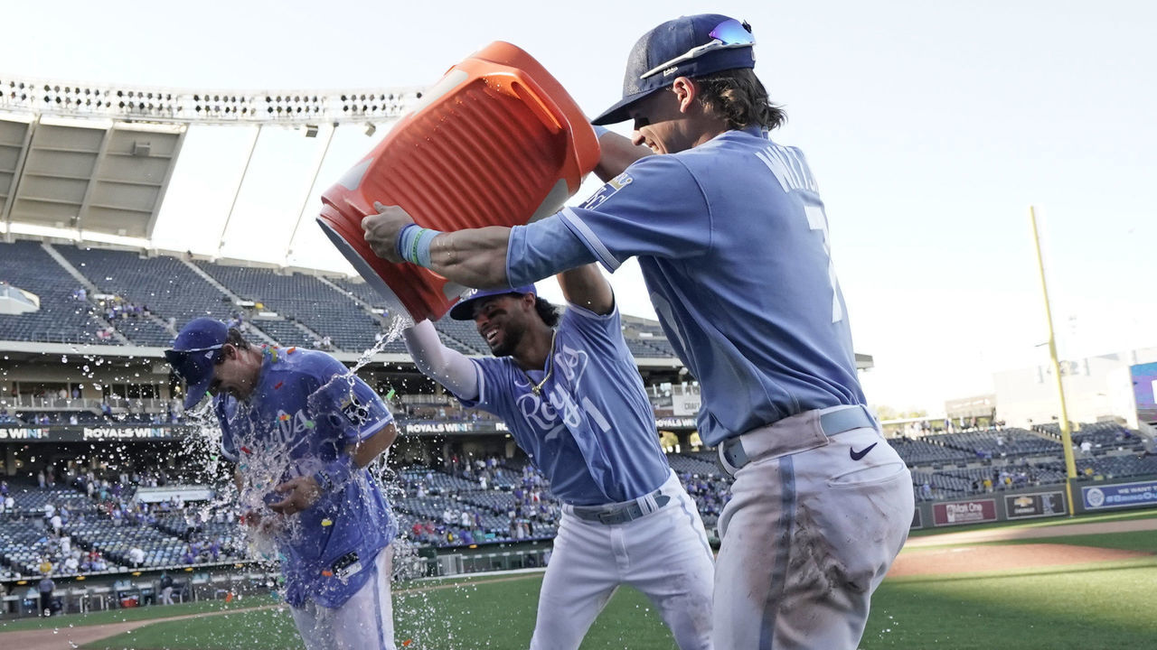 KANSAS CITY, MISSOURI - SEPTEMBER 25: Michael Massey #19 of the Kansas City Royals is doused with water by MJ Melendez #1 and Bobby Witt Jr. #7 as they celebrate a 13-12 win over the Seattle Mariners at Kauffman Stadium on September 25, 2022 in Kansas City, Missouri.