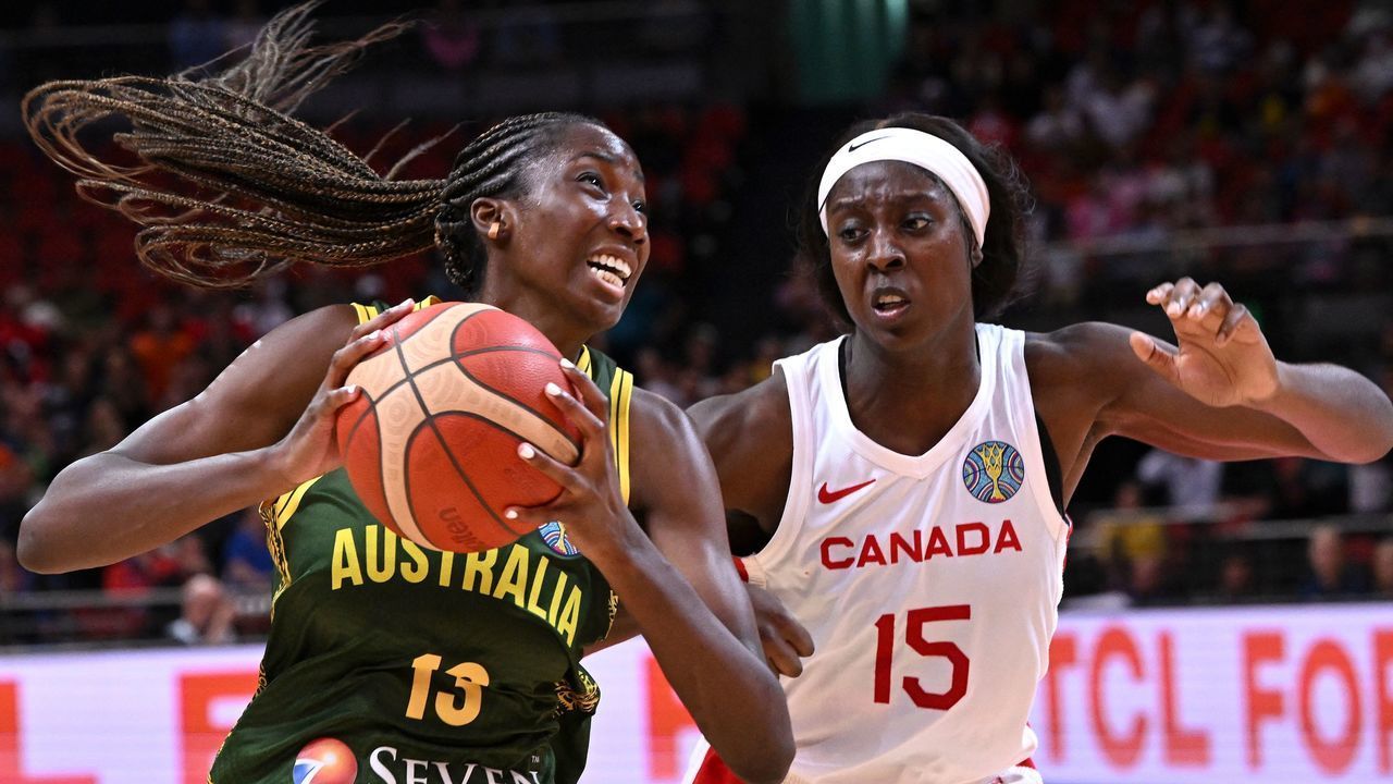 Australia's Ezi Magbegor (L) drive past Canada's Laeticia Amihere during the Women's Basketball World Cup group B game between Australia and Canada in Sydney on September 26, 2022. - -- IMAGE RESTRICTED TO EDITORIAL USE - STRICTLY NO COMMERCIAL USE --