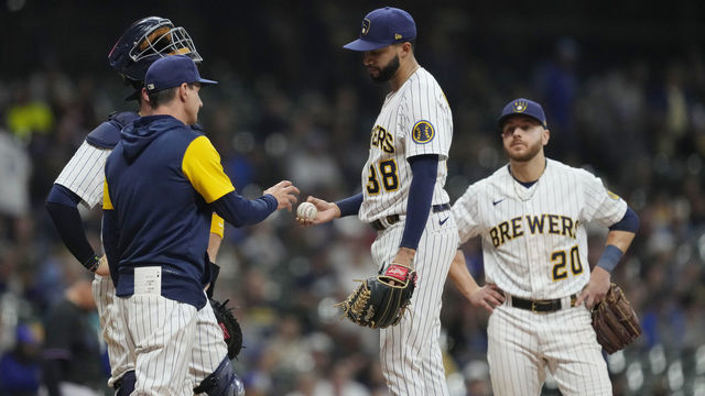 MILWAUKEE, WISCONSIN - OCTOBER 01: Devin Williams #38 of the Milwaukee Brewers hands the ball to manager Craig Counsell #30 as he is removed from the game against the Miami Marlins in the ninth inning at American Family Field on October 01, 2022 in Milwaukee, Wisconsin.