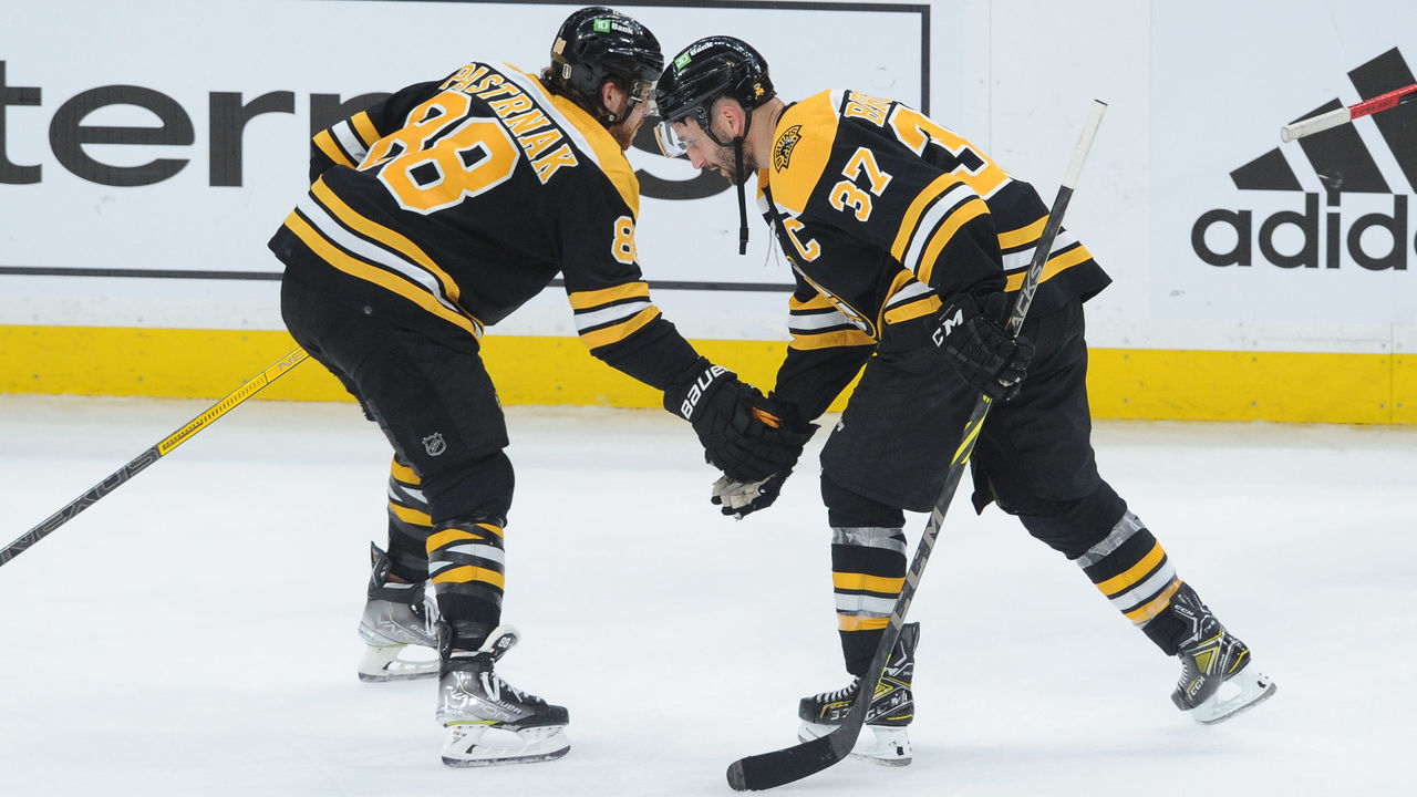 BOSTON, MA - MAY 08: David Pastrbak #88 and Patrice Bergeron #37 of the Boston Bruins celebrate the win against the Carolina Hurricanes in Game Four of the First Round of the 2022 Stanley Cup Playoffs at the TD Garden on May 8, 2022 in Boston, Massachusetts.
