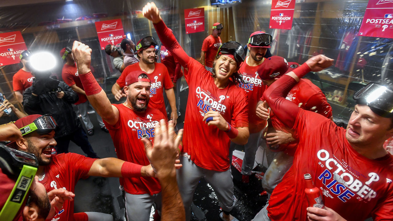 HOUSTON, TEXAS - OCTOBER 03: Kyle Schwarber #12 and Alec Bohm #28 of the Philadelphia Phillies celebrate with teammates in the locker room after clinching the Wild Card, their first playoff berth since 2011 with a 3-0 win over the Houston Astros at Minute Maid Park on October 03, 2022 in Houston, Texas.