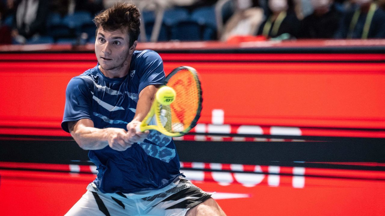 Miomir Kecmanovic of Serbia hits a return against Daniel Evans of Britain during their men's singles match at the Japan Open tennis tournament in Tokyo on October 6, 2022.