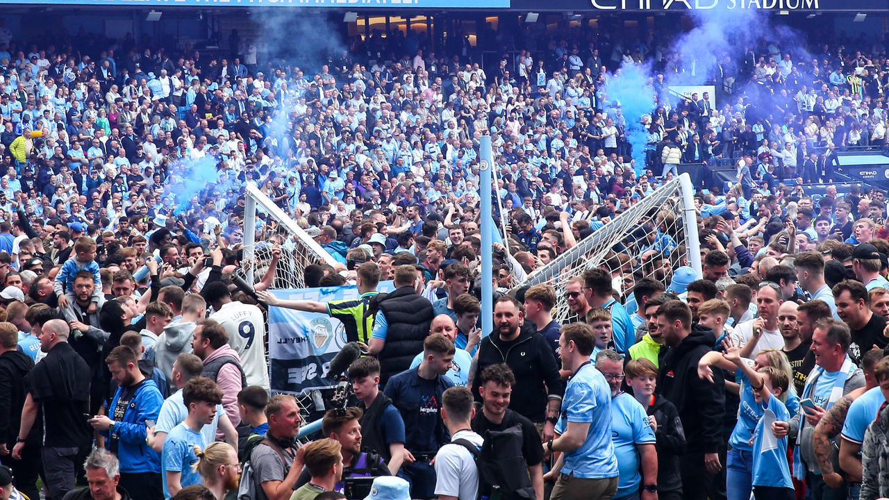 MANCHESTER, ENGLAND - MAY 22: Fans of Manchester City celebrate winning the Premier League by invading the pitch at full time and breaking the goal posts during the Premier League match between Manchester City and Aston Villa at Etihad Stadium on May 22, 2022 in Manchester, United Kingdom.