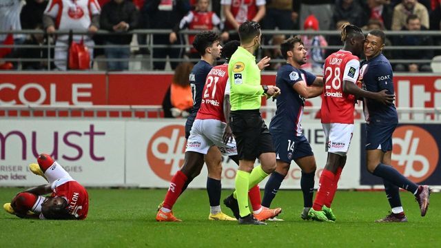 Reims' French defender Andreaw Gravillon (L) lies on the pitch as Reims' French defender Bradley Locko Banzouzi (2ndR) and Paris Saint-Germain's French forward Kylian Mbappe react during the French L1 football match between Stade de Reims and Paris Saint-Germain (PSG) at Stade Auguste-Delaune in Reims, northern France on October 8, 2022.