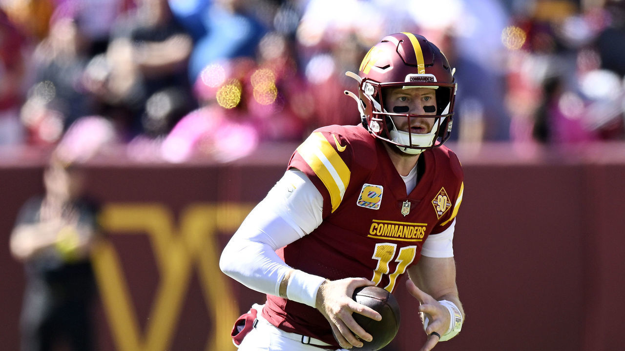 LANDOVER, MARYLAND - OCTOBER 09: Carson Wentz #11 of the Washington Commanders scrambles during the second quarter against the Tennessee Titans at FedExField on October 09, 2022 in Landover, Maryland.