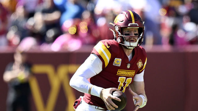LANDOVER, MARYLAND - OCTOBER 09: Carson Wentz #11 of the Washington Commanders scrambles during the second quarter against the Tennessee Titans at FedExField on October 09, 2022 in Landover, Maryland.