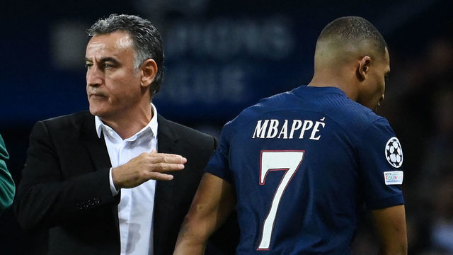 Paris Saint-Germain's French forward Kylian Mbappe (R) leaves the pitch after he is substituted by Paris Saint-Germain's French head coach Christophe Galtier (L) during the UEFA Champions League group H football match between Paris Saint-Germain (PSG) and SL Benfica, at The Parc des Princes Stadium, on October 11, 2022.