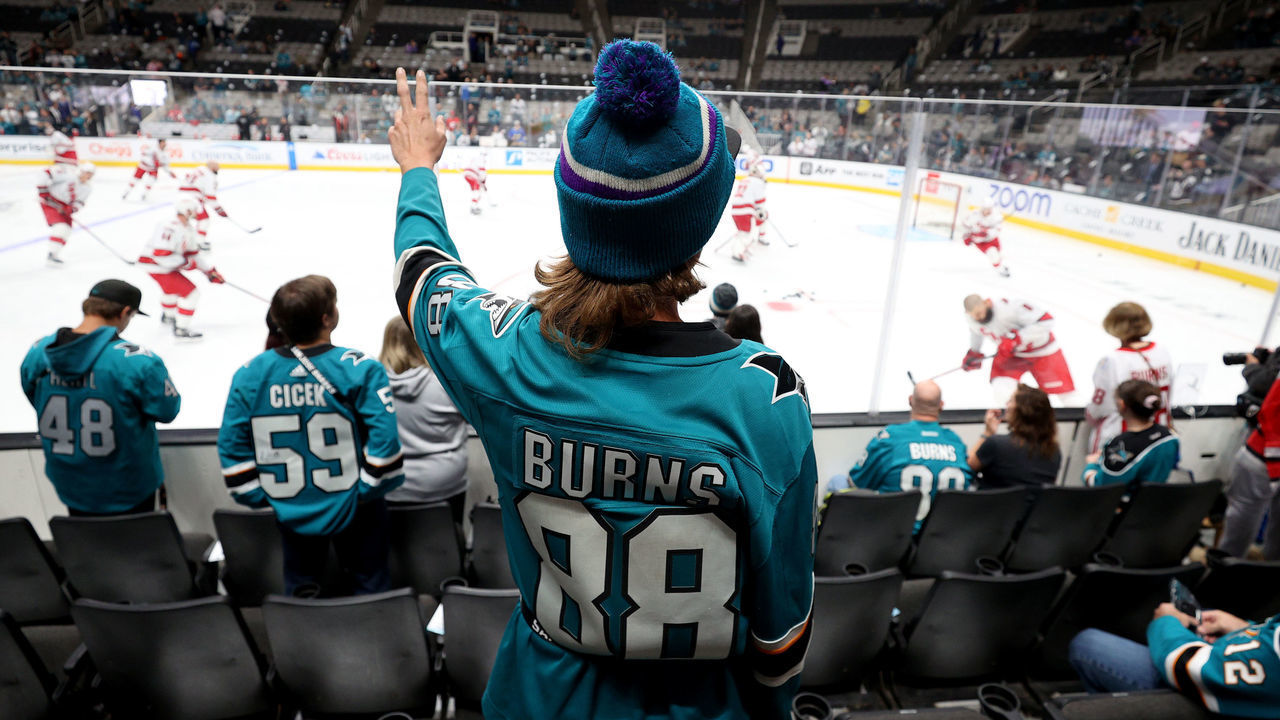 SAN JOSE, CALIFORNIA - OCTOBER 14: A fan watches Brent Burns #8 of the Carolina Hurricanes warm up before their game against the San Jose Sharks at SAP Center on October 14, 2022 in San Jose, California. Burns played for the Sharks for 11 seasons and is the franchise's all-time leader in goals, assists, and points.
