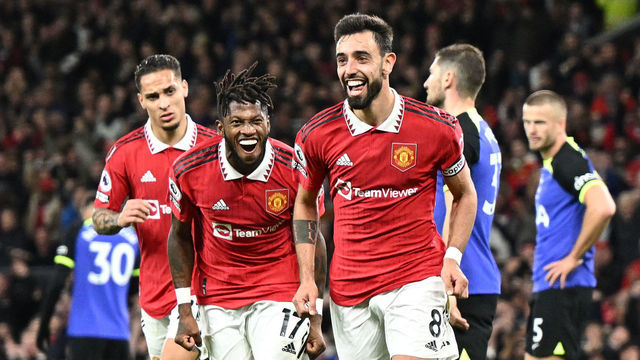 Manchester United's Portuguese midfielder Bruno Fernandes (C) celebrates after scoring his team second goal during the English Premier League football match between Manchester United and Tottenham Hotspur at Old Trafford in Manchester, north west England, on October 19, 2022. - RESTRICTED TO EDITORIAL USE. No use with unauthorized audio, video, data, fixture lists, club/league logos or 'live' services. Online in-match use limited to 120 images. An additional 40 images may be used in extra time. No video emulation. Social media in-match use limited to 120 images. An additional 40 images may be used in extra time. No use in betting publications, games or single club/league/player publications.