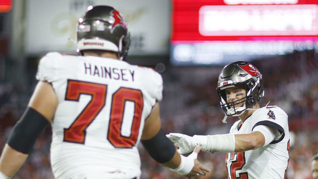 TAMPA, FLORIDA - OCTOBER 02: Tom Brady #12 of the Tampa Bay Buccaneers fist bumps Robert Hainsey #70 prior to the game against the Kansas City Chiefs at Raymond James Stadium on October 02, 2022 in Tampa, Florida.