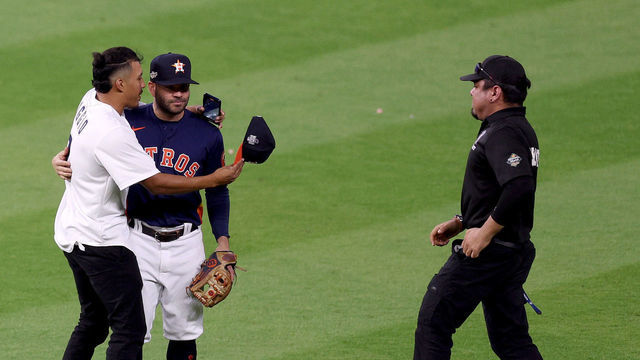 HOUSTON, TEXAS - OCTOBER 20: A fan enters the field and greets Jose Altuve #27 of the Houston Astros during the ninth inning in game two of the American League Championship Series against the New York Yankees at Minute Maid Park on October 20, 2022 in Houston, Texas.