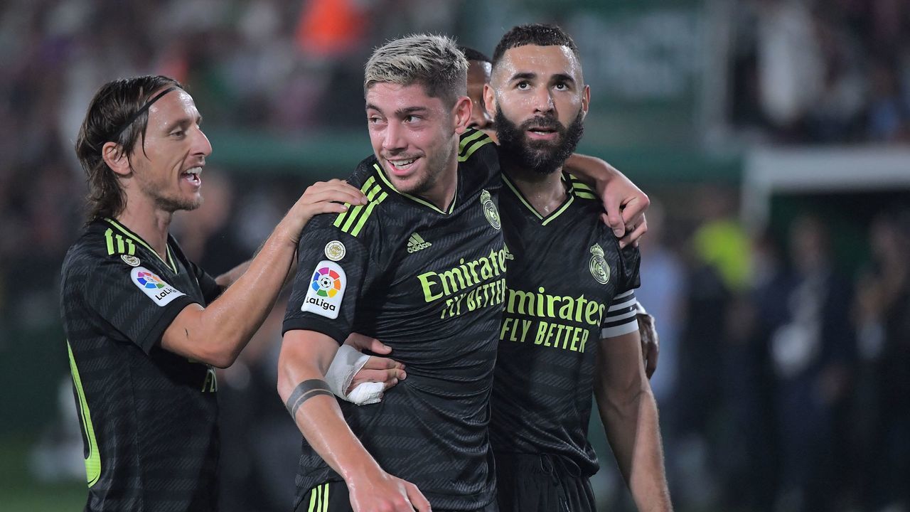 Real Madrid's Uruguayan midfielder Federico Valverde celebrates with Real Madrid's Croatian midfielder Luka Modric (L) and Real Madrid's French forward Karim Benzema (R) scoring his team's first goal during the Spanish league football match between Elche CF and Real Madrid CF at the Martinez Valero stadium in Elche on October 19, 2022.