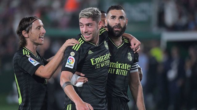 Real Madrid's Uruguayan midfielder Federico Valverde celebrates with Real Madrid's Croatian midfielder Luka Modric (L) and Real Madrid's French forward Karim Benzema (R) scoring his team's first goal during the Spanish league football match between Elche CF and Real Madrid CF at the Martinez Valero stadium in Elche on October 19, 2022.