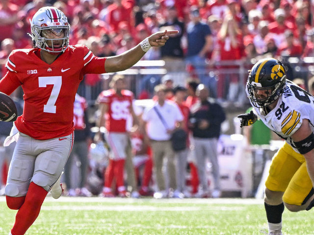 COLUMBUS, OHIO - OCTOBER 22: Quarterback C.J. Stroud #7 of the Ohio State Buckeyes looks for an open receiver while eluding defensive lineman John Waggoner #92 of the Iowa Hawkeyes in the fourth quarter at Ohio Stadium on October 22, 2022 in Columbus, Ohio.