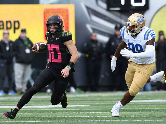 EUGENE, OR - OCTOBER 22: Oregon Ducks quarterback Bo Nix (10) runs the ball against UCLA Bruins defensive lineman Jacob Sykes (99) during a PAC-12 Conference college football game between the UCLA Bruins and Oregon Ducks on October 22, 2022 at Autzen Stadium in Eugene, Oregon.