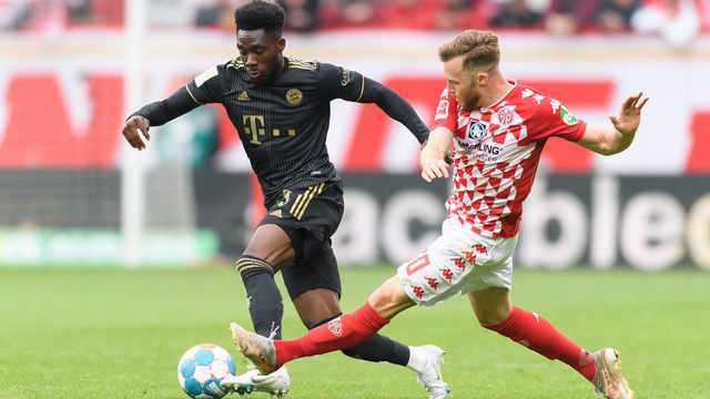 MAINZ, GERMANY - APRIL 30: Alphonso Davies of Bayern Muenchen udn Silvan Widmer of 1. FSV Mainz 05 battle for the ball during the Bundesliga match between 1. FSV Mainz 05 and FC Bayern München at MEWA Arena on April 30, 2022 in Mainz, Germany.