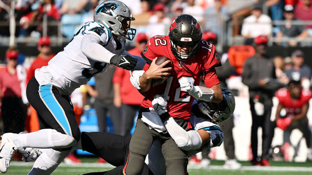 CHARLOTTE, NORTH CAROLINA - OCTOBER 23: Frankie Luvu #49 of the Carolina Panthers tackles Tom Brady #12 of the Tampa Bay Buccaneers in the third quarter at Bank of America Stadium on October 23, 2022 in Charlotte, North Carolina.