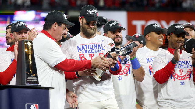 PHILADELPHIA, PA - OCTOBER 23: Bryce Harper #3 of the Philadelphia Phillies holds the Warren C. Giles trophy on the podium after taking Game 5 and winning the NLCS against the San Diego Padres at Citizens Bank Park on Sunday, October 23, 2022 in Philadelphia, Pennsylvania.