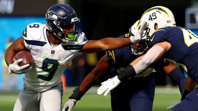 INGLEWOOD, CALIFORNIA - OCTOBER 23: Kenneth Walker III #9 of the Seattle Seahawks runs the ball against Drue Tranquill #49 of the Los Angeles Chargers during the first quarter at SoFi Stadium on October 23, 2022 in Inglewood, California. The Seattle Seahawks won 37-23.