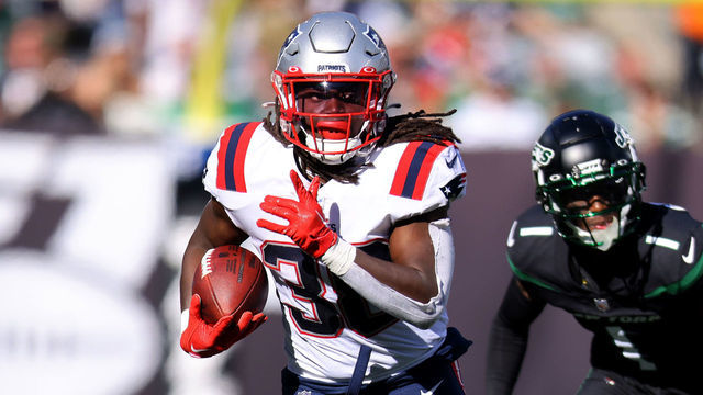 EAST RUTHERFORD, NEW JERSEY - OCTOBER 30: Rhamondre Stevenson #38 of the New England Patriots runs with the ball as Sauce Gardner #1 of the New York Jets defends during the first half at MetLife Stadium on October 30, 2022 in East Rutherford, New Jersey.
