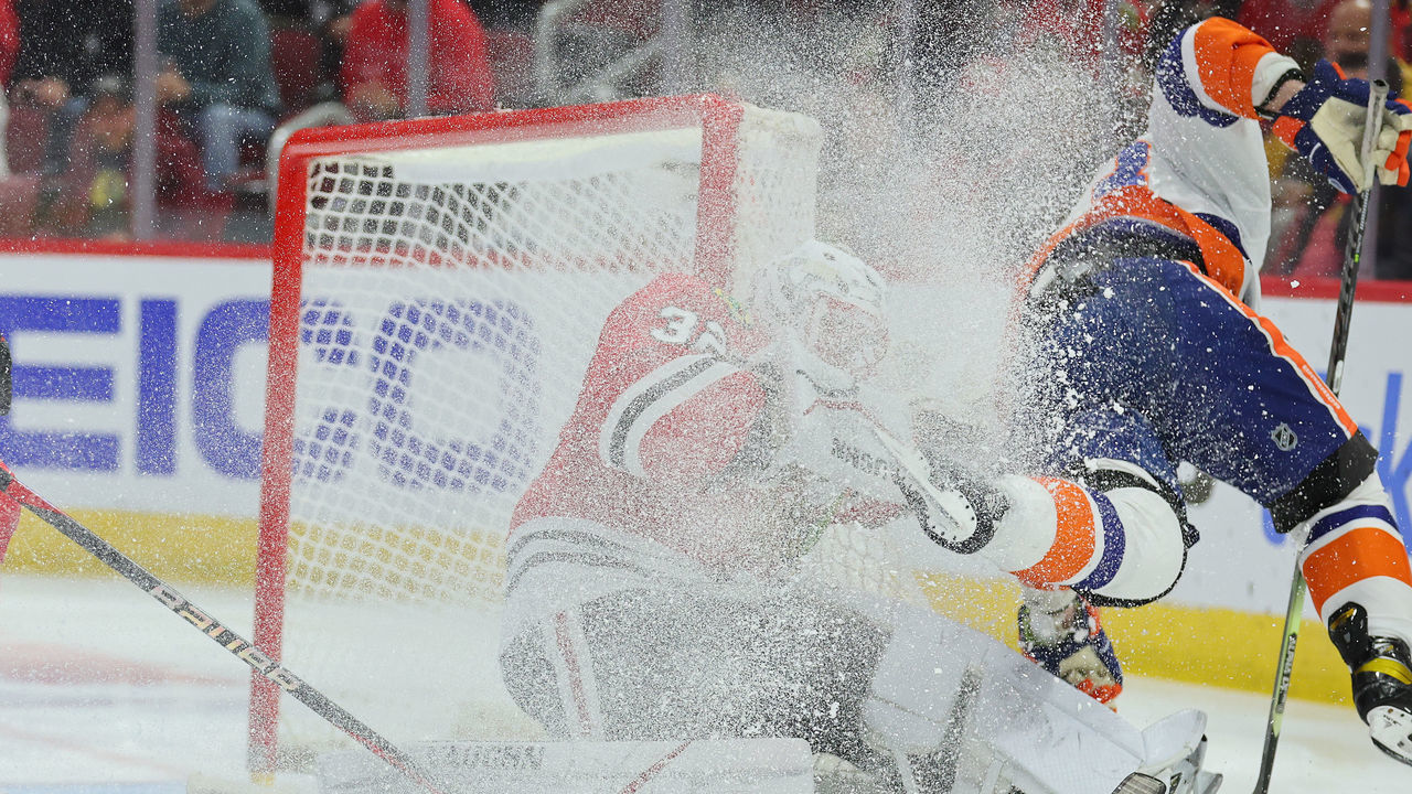 CHICAGO, ILLINOIS - NOVEMBER 01: Casey Cizikas #53 of the New York Islanders collides with Alex Stalock #32 of the Chicago Blackhawks during the first period at United Center on November 01, 2022 in Chicago, Illinois.