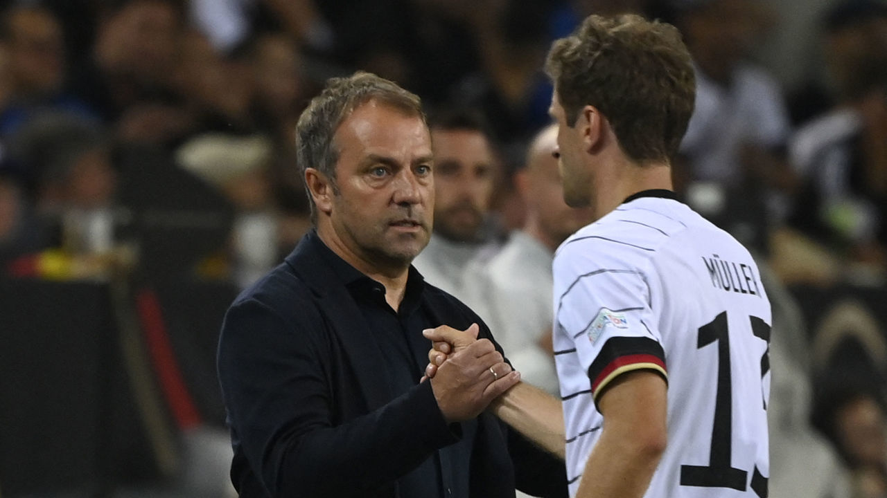Germany's coach Hans-Dieter Flick (R) shakes hands with Germany's forward Thomas Mueller (R) as he leaves the pitch after being substituted off during the UEFA Nations League football match Germany v Italy at the Borussia Park stadium in Moenchengladbach, western Germany, on June 14, 2022.