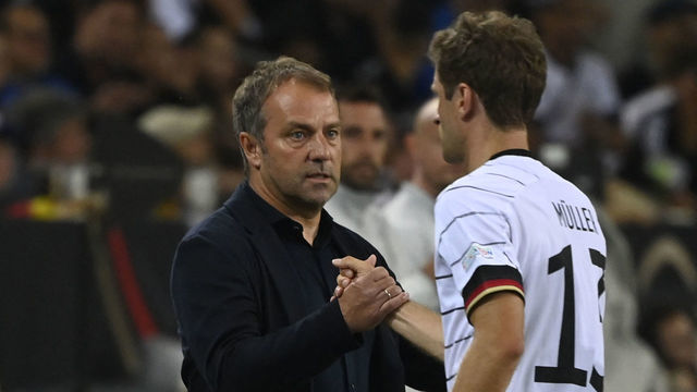 Germany's coach Hans-Dieter Flick (R) shakes hands with Germany's forward Thomas Mueller (R) as he leaves the pitch after being substituted off during the UEFA Nations League football match Germany v Italy at the Borussia Park stadium in Moenchengladbach, western Germany, on June 14, 2022.