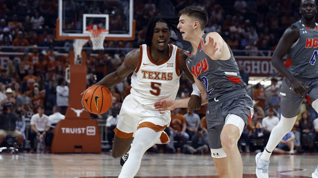 AUSTIN, TX - NOVEMBER 10: Texas Longhorns guard Marcus Carr drives past against Houston Baptist Huskies guard Pierce Bazil during the game at the Moody Center in Austin, TX on November 10, 2022.