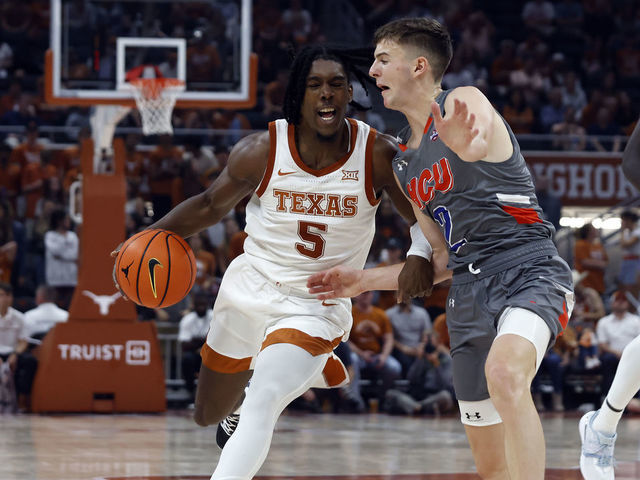 AUSTIN, TX - NOVEMBER 10: Texas Longhorns guard Marcus Carr drives past against Houston Baptist Huskies guard Pierce Bazil during the game at the Moody Center in Austin, TX on November 10, 2022.