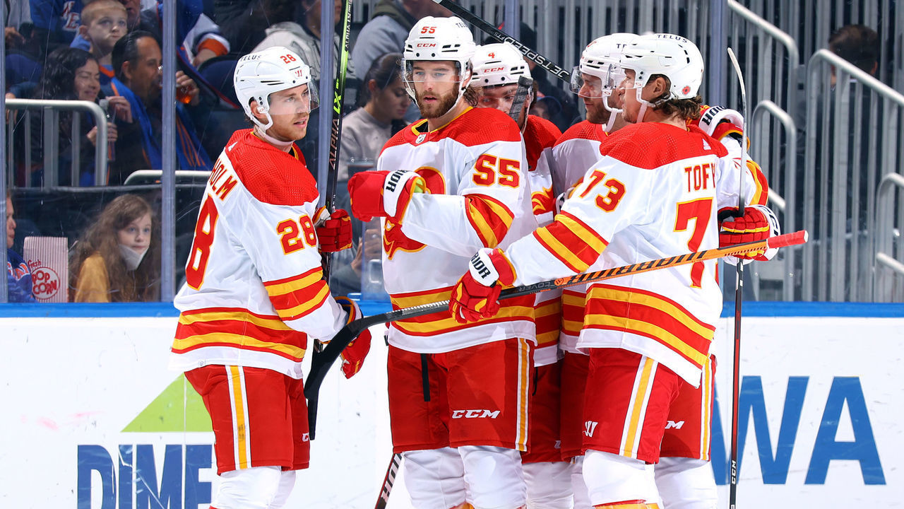 ELMONT, NEW YORK - NOVEMBER 07: Elias Lindholm #28 of the Calgary Flames is congratulated by his teammates after scoring a goal against the New York Islanders during the first period at UBS Arena on November 07, 2022 in Elmont, New York.
