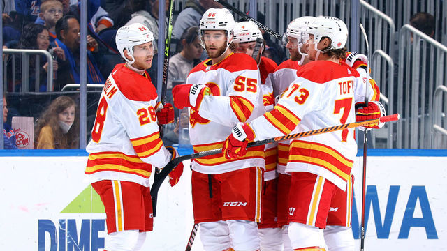 ELMONT, NEW YORK - NOVEMBER 07: Elias Lindholm #28 of the Calgary Flames is congratulated by his teammates after scoring a goal against the New York Islanders during the first period at UBS Arena on November 07, 2022 in Elmont, New York.