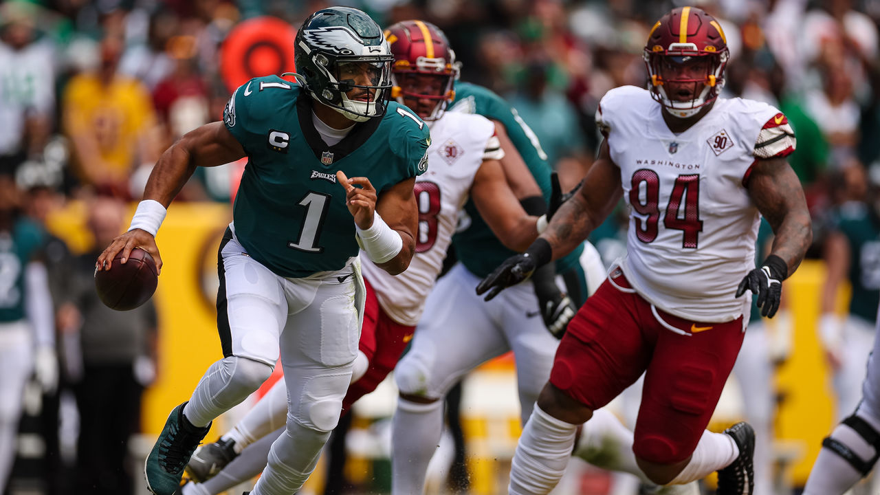 LANDOVER, MD - SEPTEMBER 25: Jalen Hurts #1 of the Philadelphia Eagles scrambles from the pressure of Daron Payne #94 of the Washington Commanders during the first half at FedExField on September 25, 2022 in Landover, Maryland.
